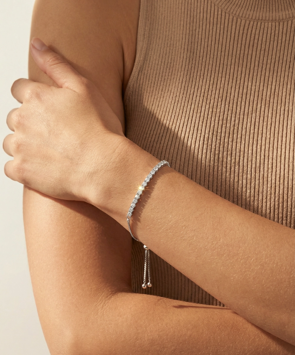 Silver bracelet on a person's wrist with a neutral background