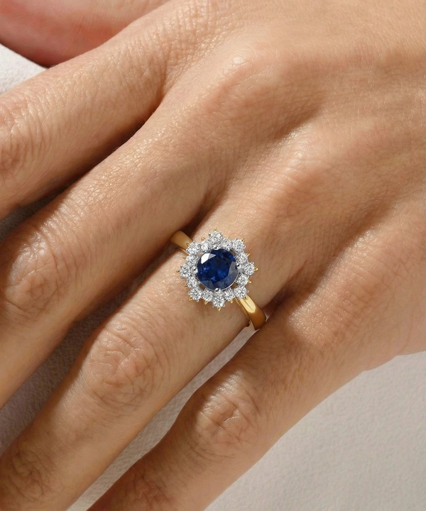 Gold ring with a blue gemstone on a hand against a neutral background