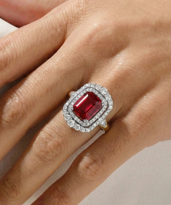 Ring with a red gemstone and diamond accents on a hand
