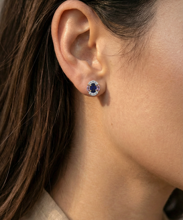 Close-up of an ear wearing a blue gemstone earring.