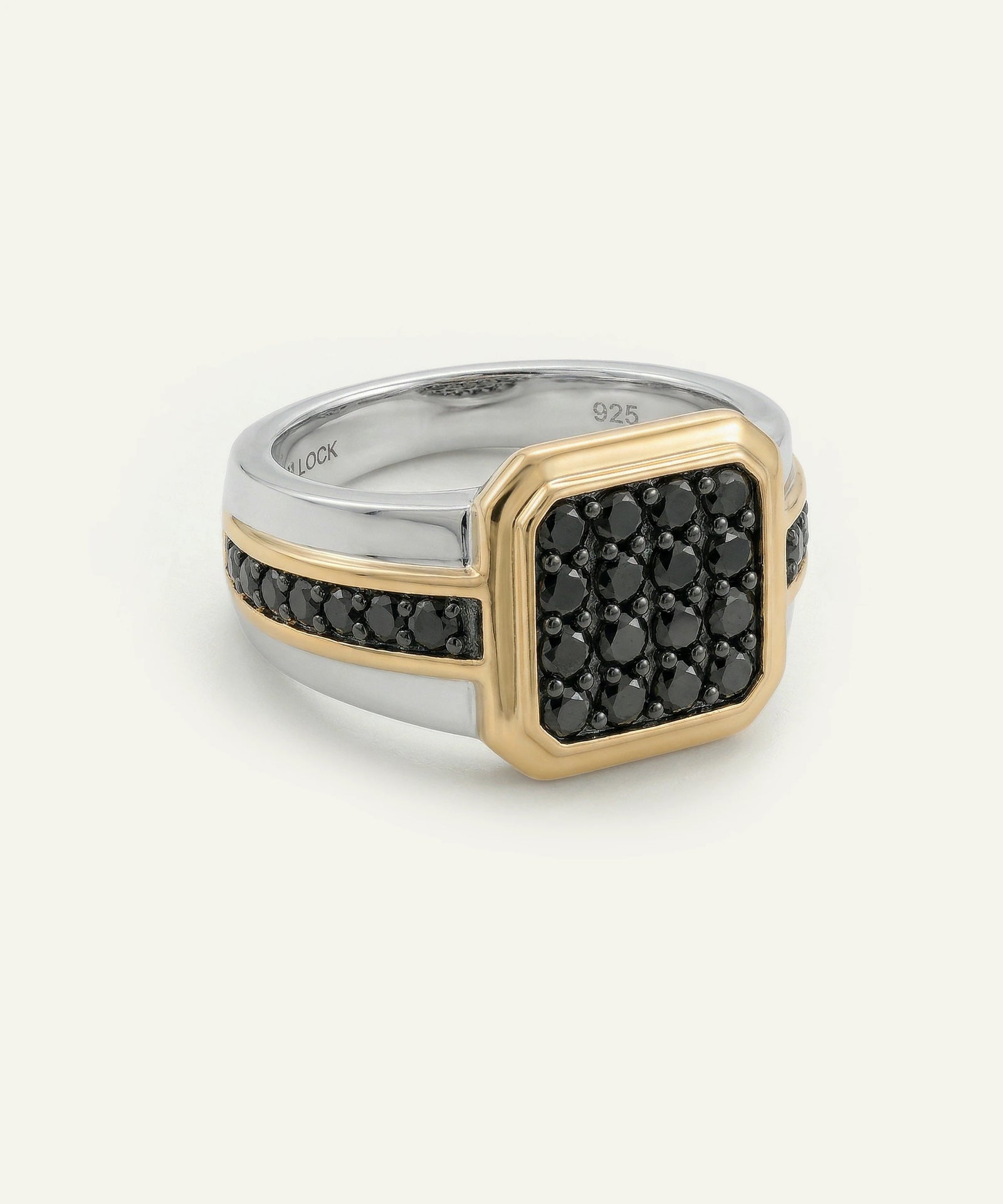 Two-tone ring with black gemstones on a white background