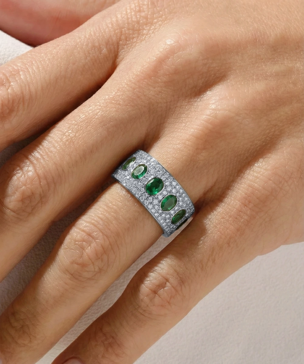Ring with blue gemstones on a hand against a neutral background