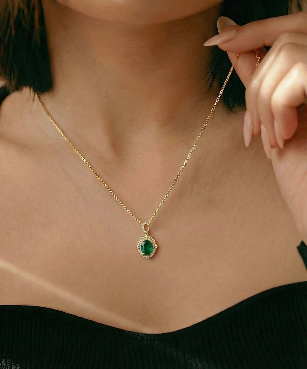 Gold necklace with a green gemstone pendant worn by a person.