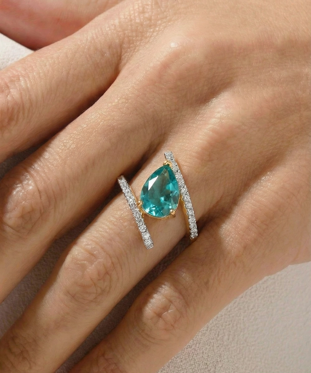 Teal gemstone ring with diamond accents on a hand