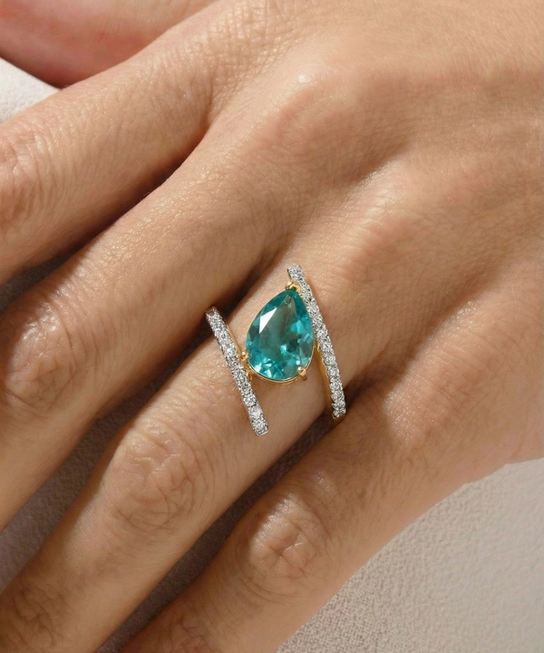 Teal gemstone ring with diamond accents on a hand