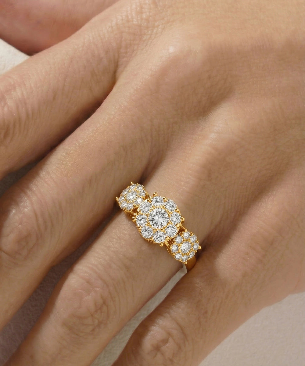 Gold ring with diamonds on a hand against a neutral background