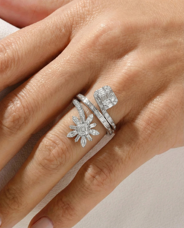 Silver ring with diamond accents on a hand against a neutral background
