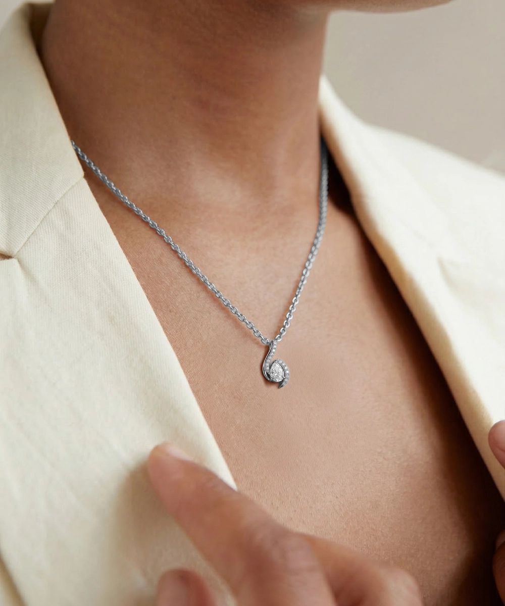 Necklace with a pendant worn by a person in a light-colored outfit