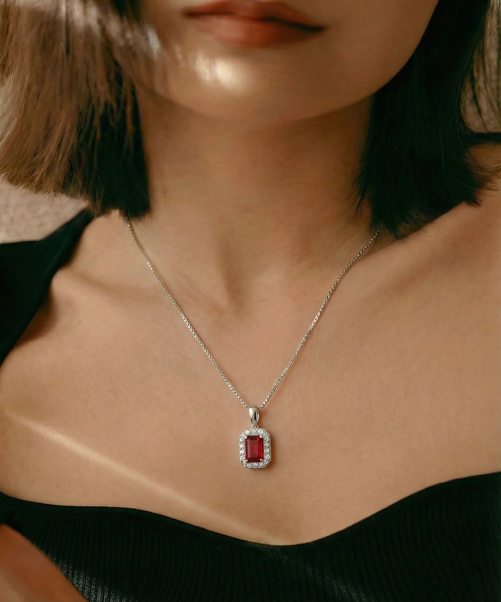 Necklace with a red gemstone pendant worn by a person