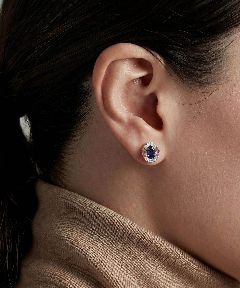 Close-up of an ear wearing a sapphire earring with a blurred background