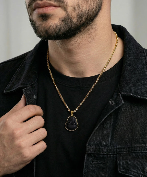 Man wearing a gold chain necklace with a pendant, holding his jacket open.