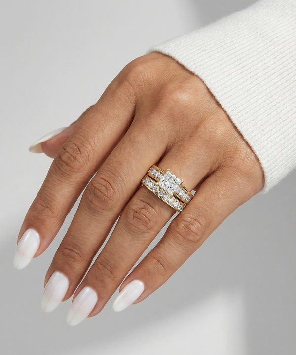 Hand wearing a diamond ring on a neutral background