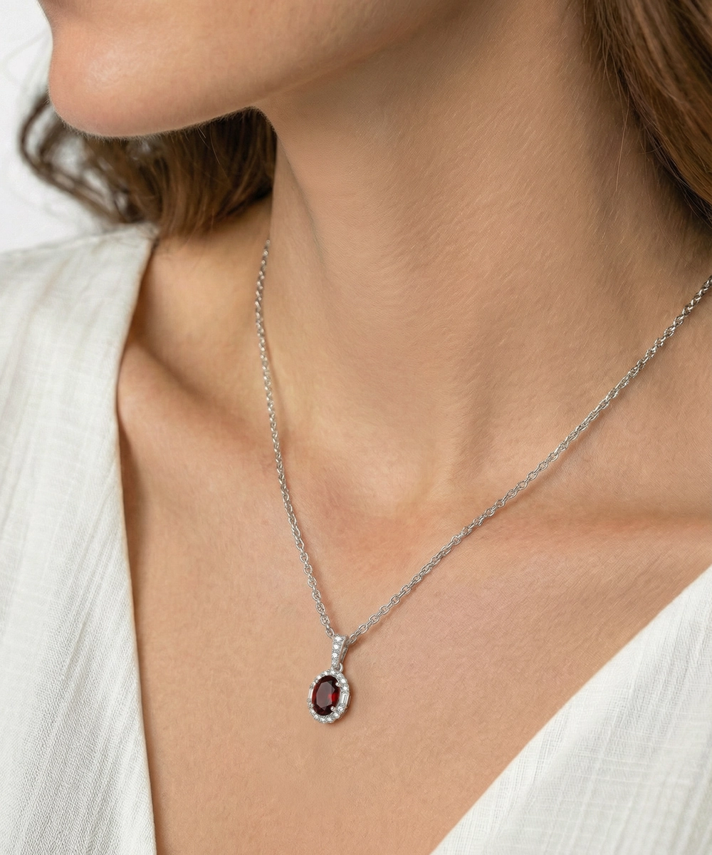 Necklace with a pendant worn by a person in a white outfit