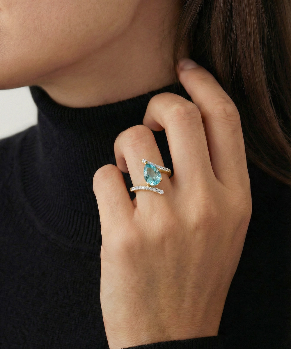 Close-up of a hand wearing two turquoise gemstone rings on a blurred background