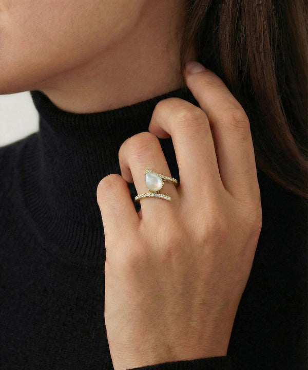 Close-up of a hand wearing two rings with a black background