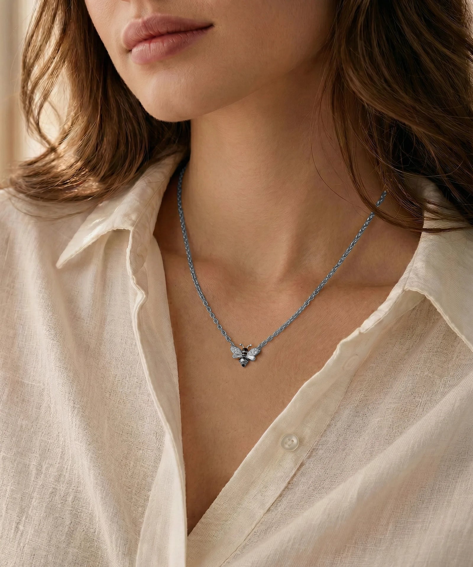 Close-up of a person wearing a delicate necklace with a butterfly pendant.