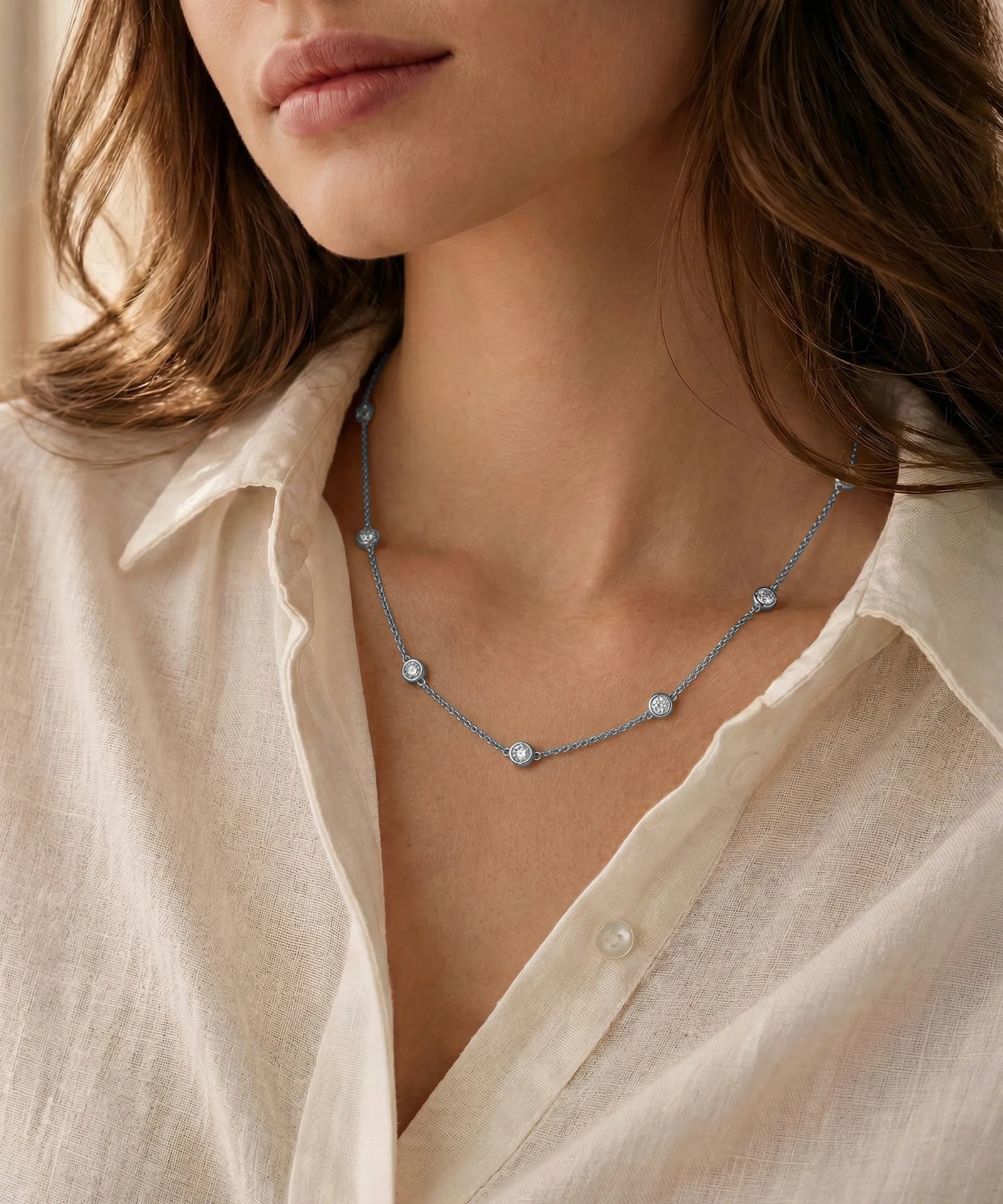 Close-up of a person wearing a delicate gold necklace with small pearls.