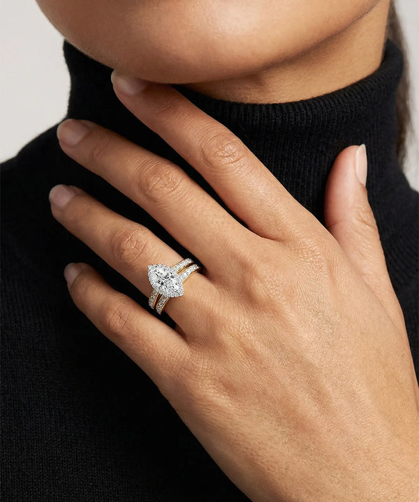 Hand wearing a diamond ring with a black turtleneck sweater