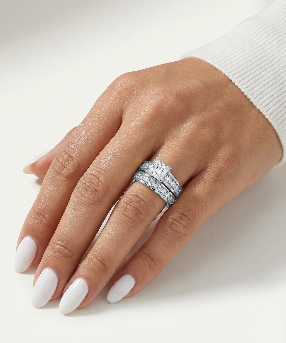 Hand wearing a silver ring with a diamond on a white background