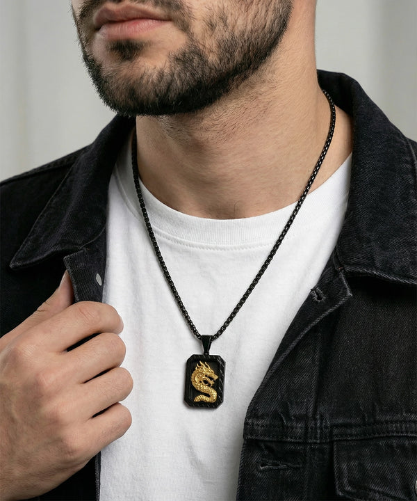 Man wearing a black necklace with a gold dragon pendant.