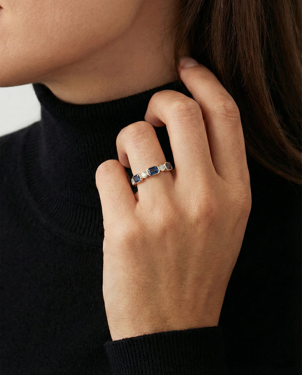 Close-up of a hand wearing a ring with a black background