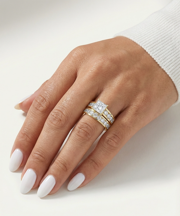Hand wearing a gold ring with a diamond on a white background