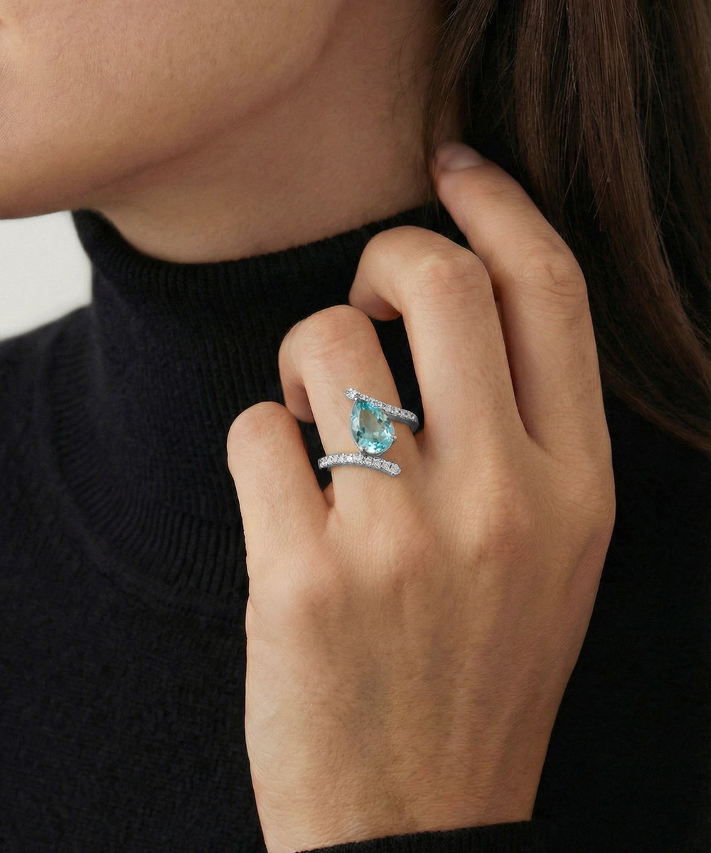 Close-up of a hand wearing two turquoise rings with a blurred background