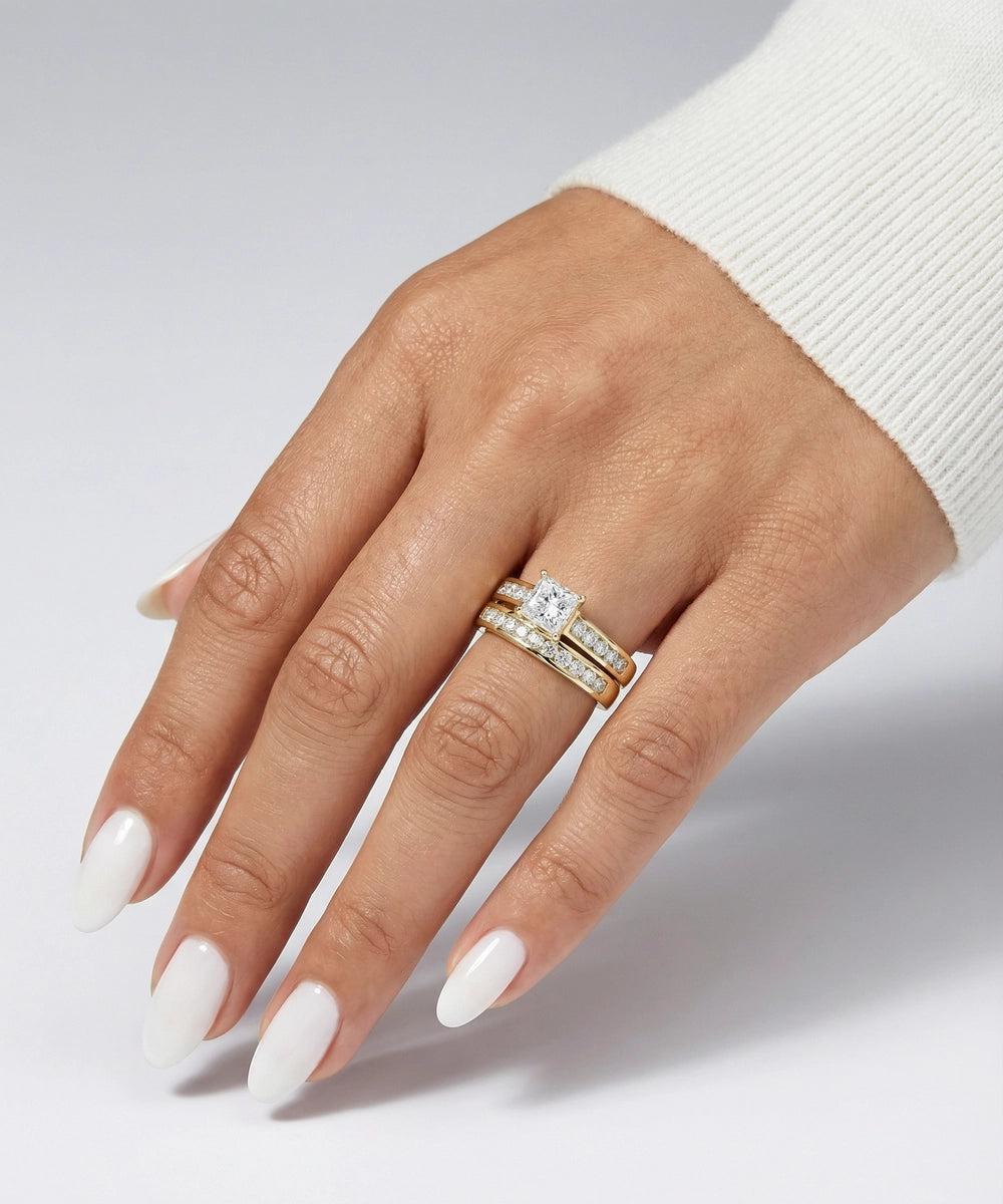 Hand wearing a diamond ring on a light gray background