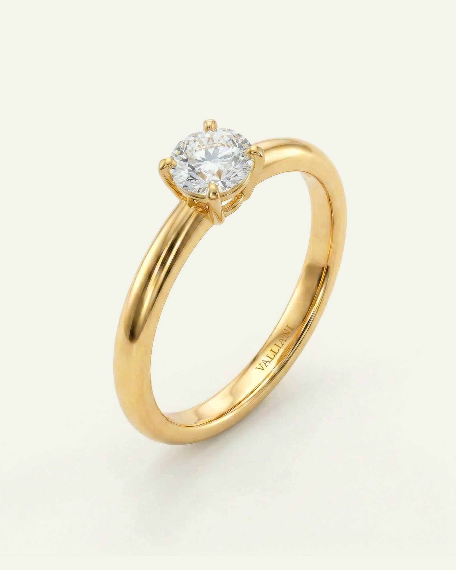 Gold ring with a diamond on a light gray background