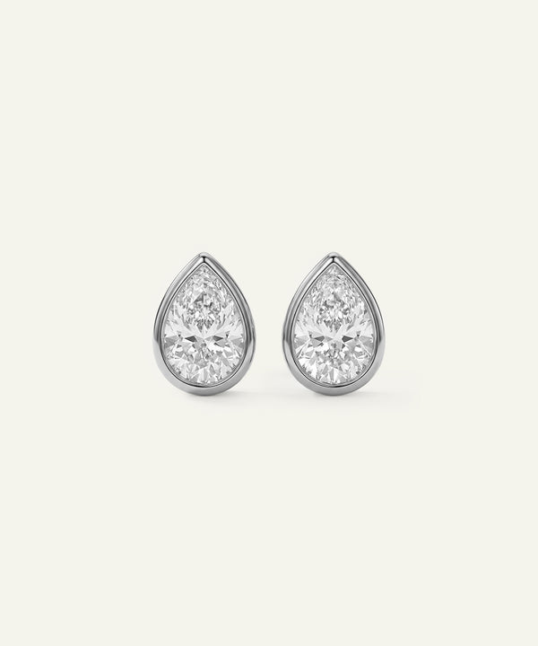 Pair of teardrop-shaped diamond earrings on a light gray background