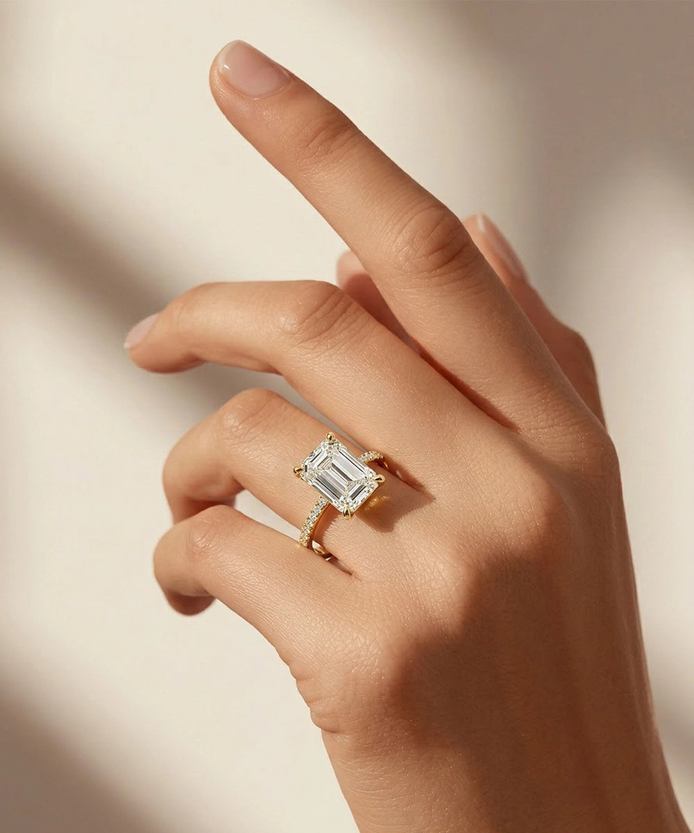 Hand wearing a diamond ring on a neutral background