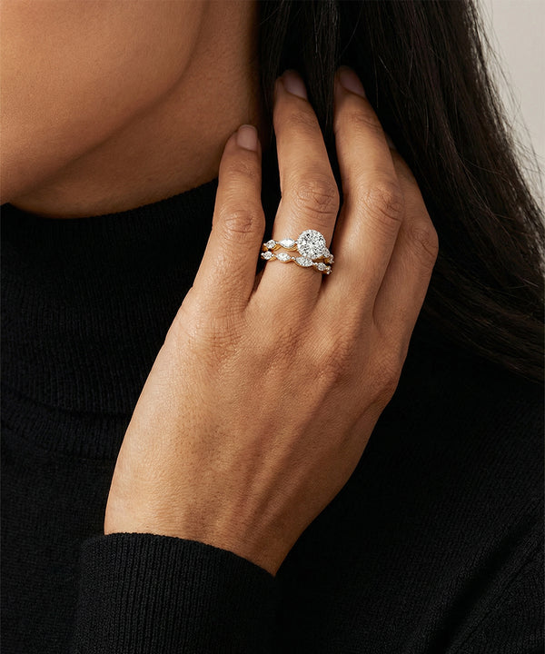 Close-up of a hand wearing a diamond ring with a blurred background
