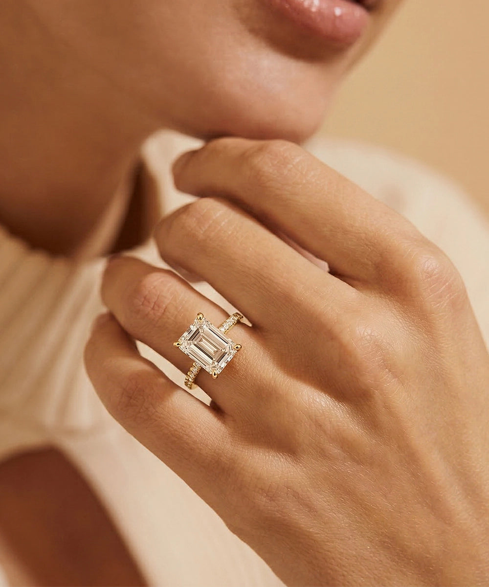 Close-up of a hand wearing a diamond ring with a soft focus background