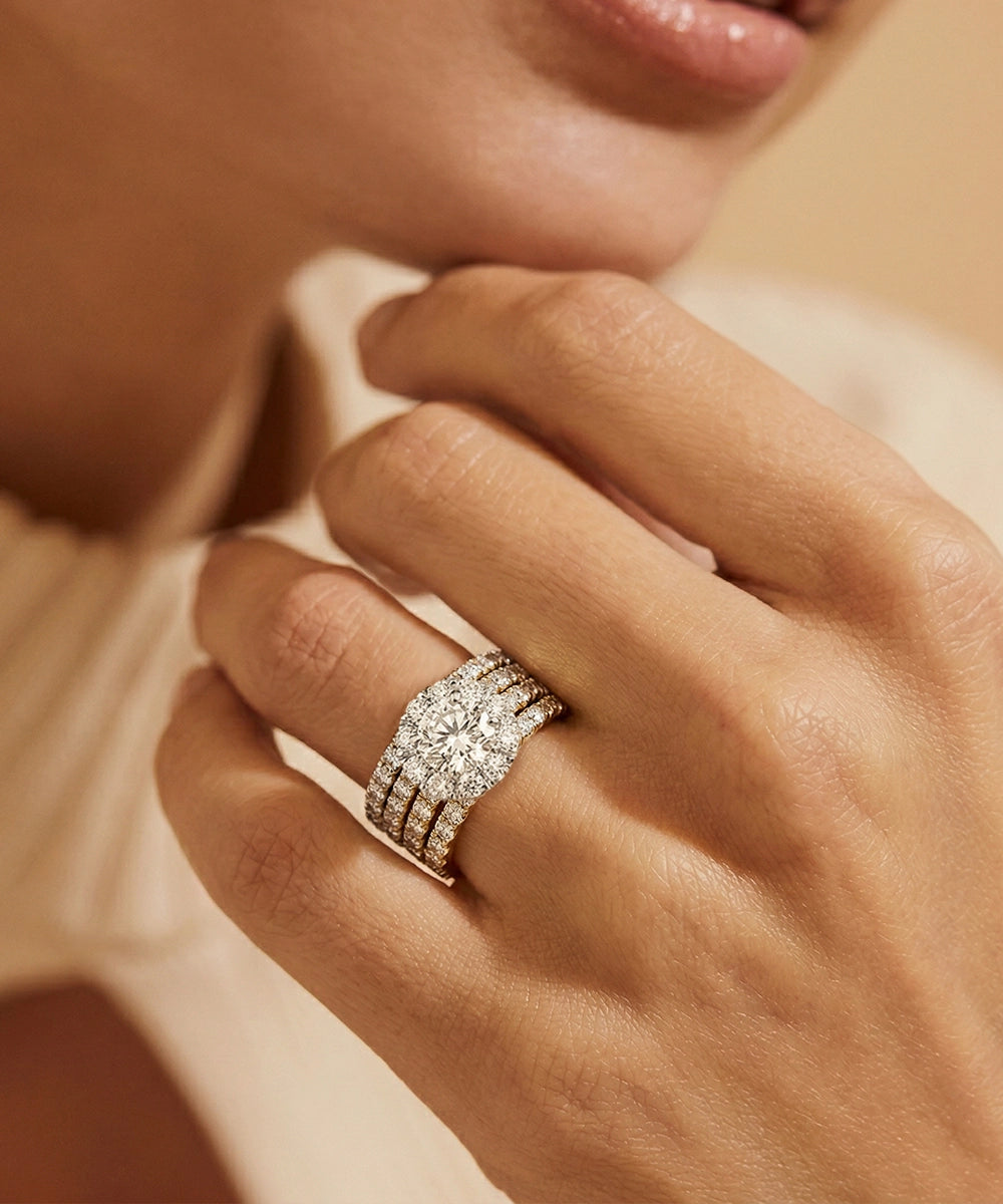 Close-up of a hand wearing a diamond ring with a soft focus background