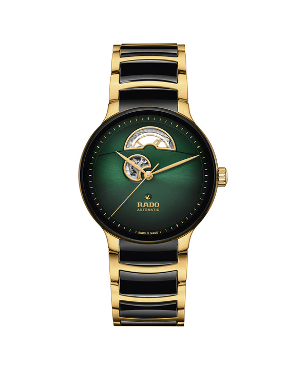 Gold and black watch with green face on a white background