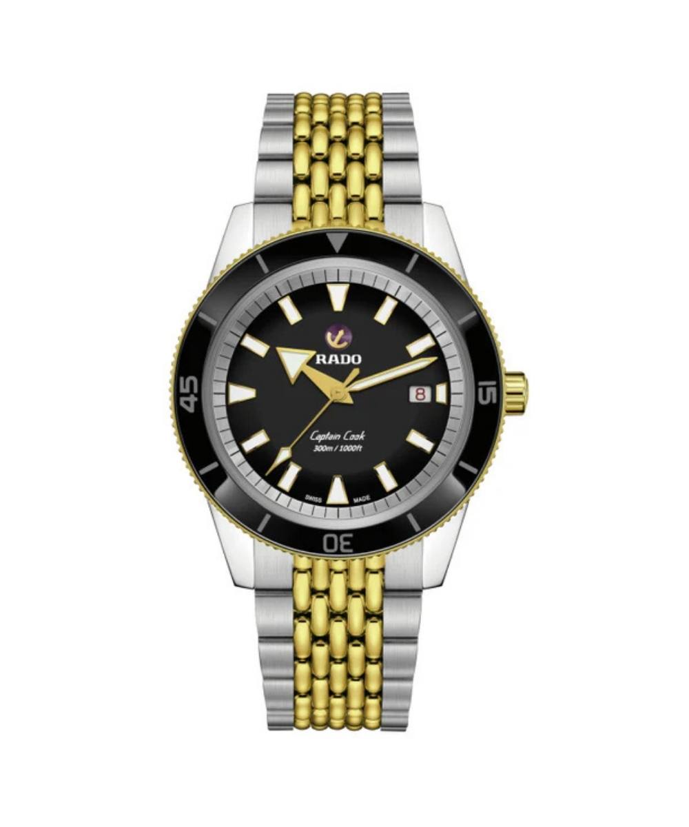 Watch with a black face, gold and silver metal band on a white background