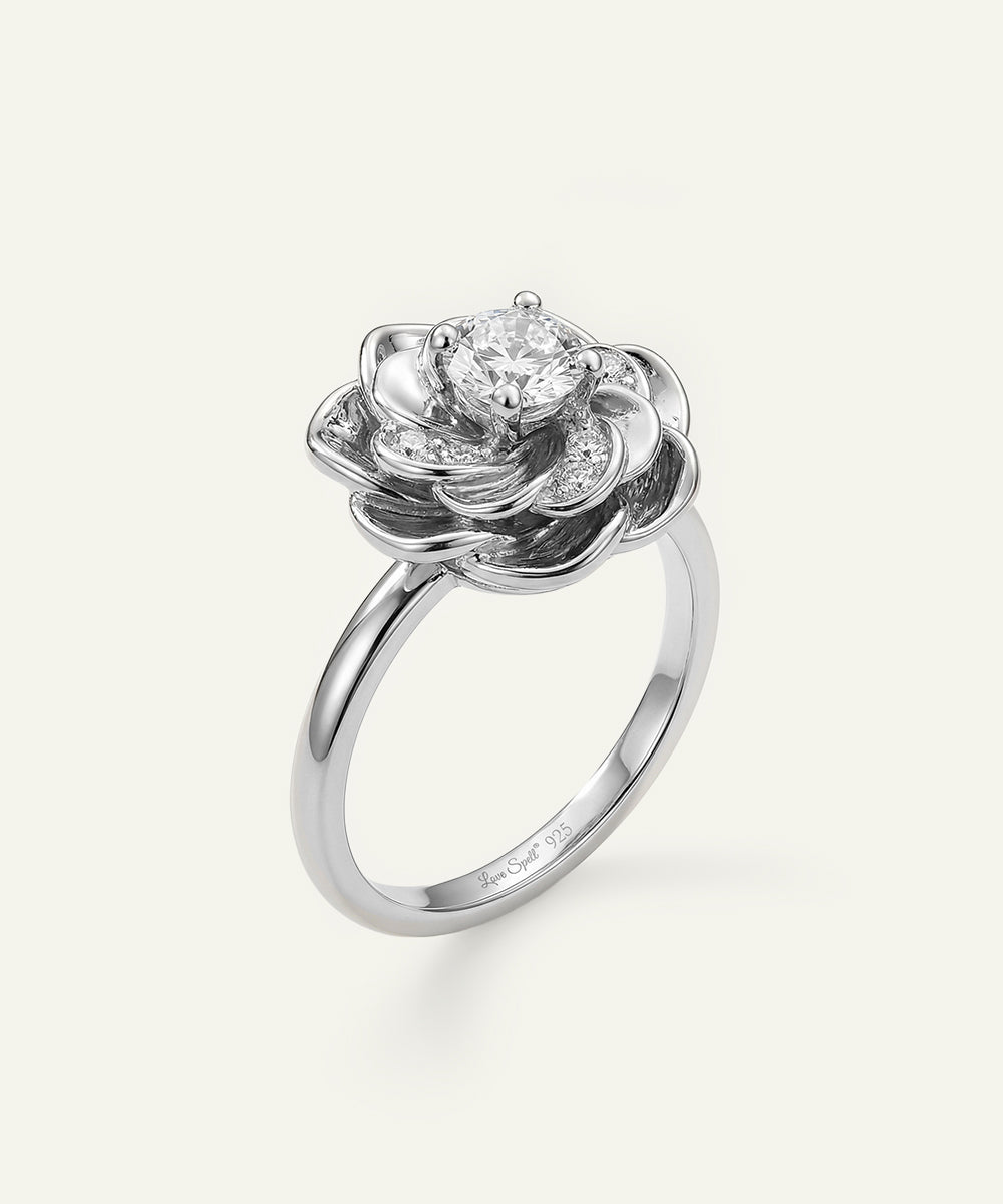 Silver rose-shaped ring with a diamond on a white background