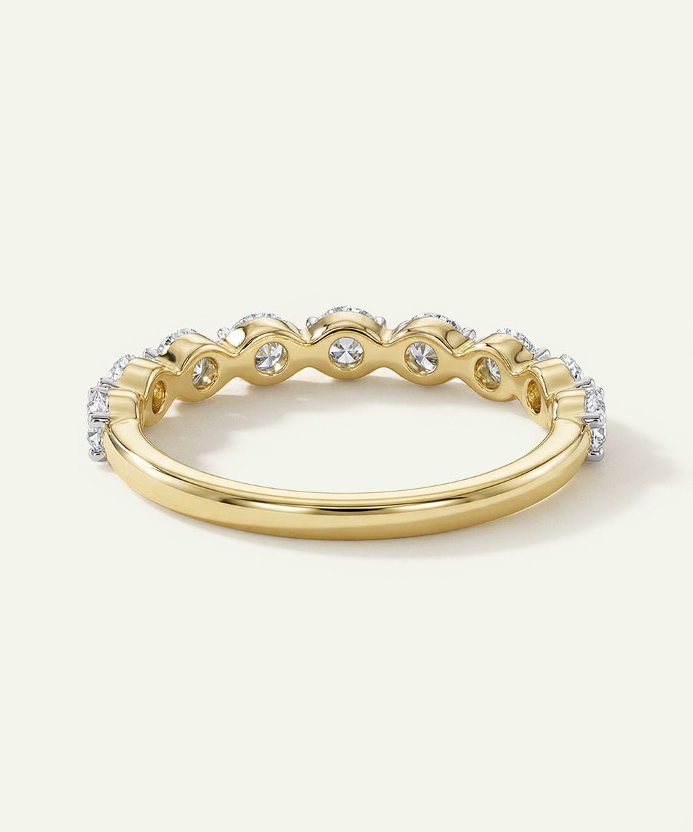 Gold ring with diamond accents on a light background