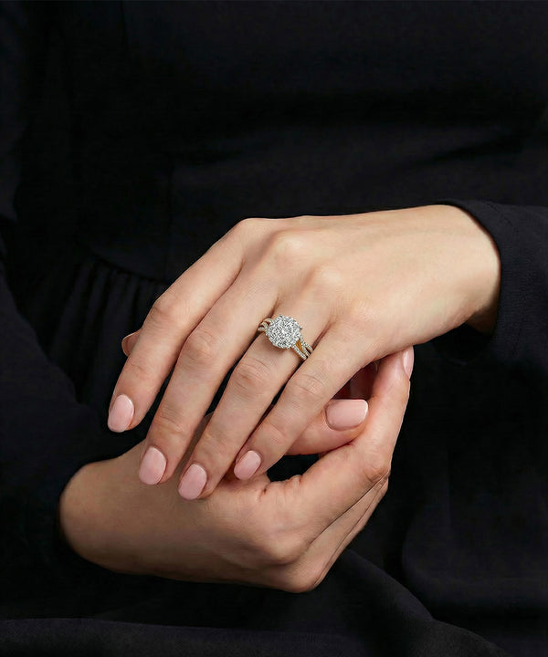 Close-up of a hand wearing a diamond ring with a dark background