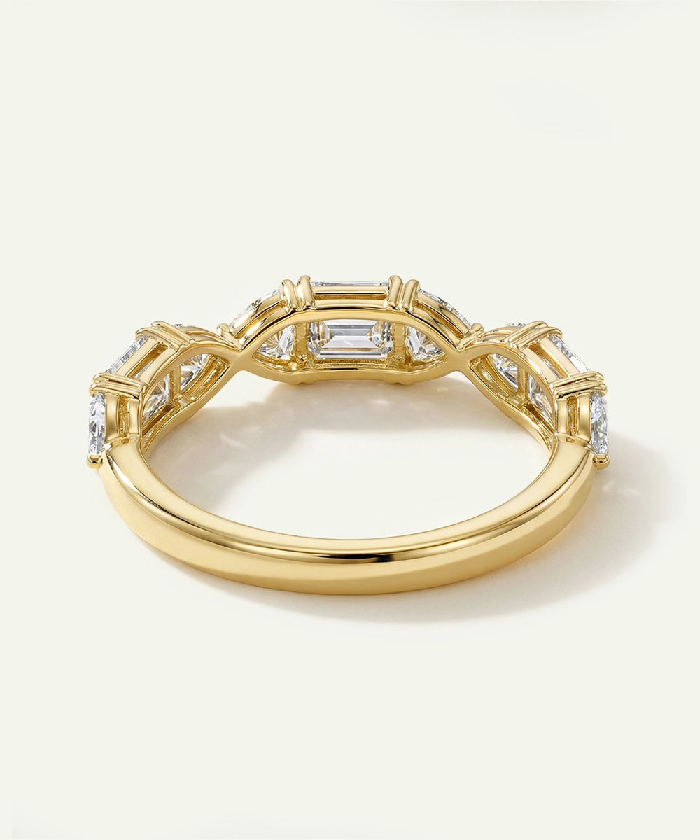 Gold ring with diamond accents on a light background