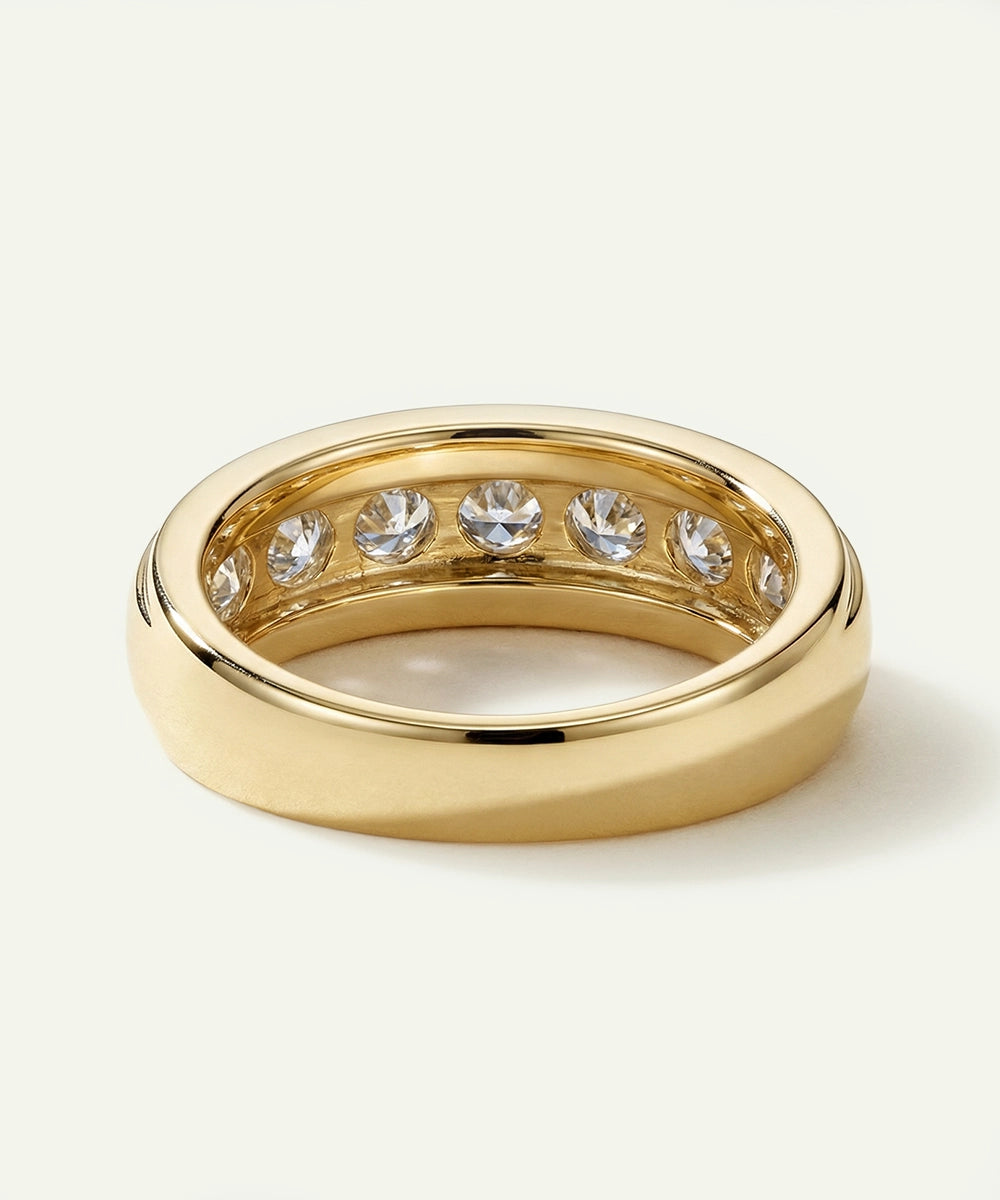 Gold ring with embedded diamonds on a light beige background