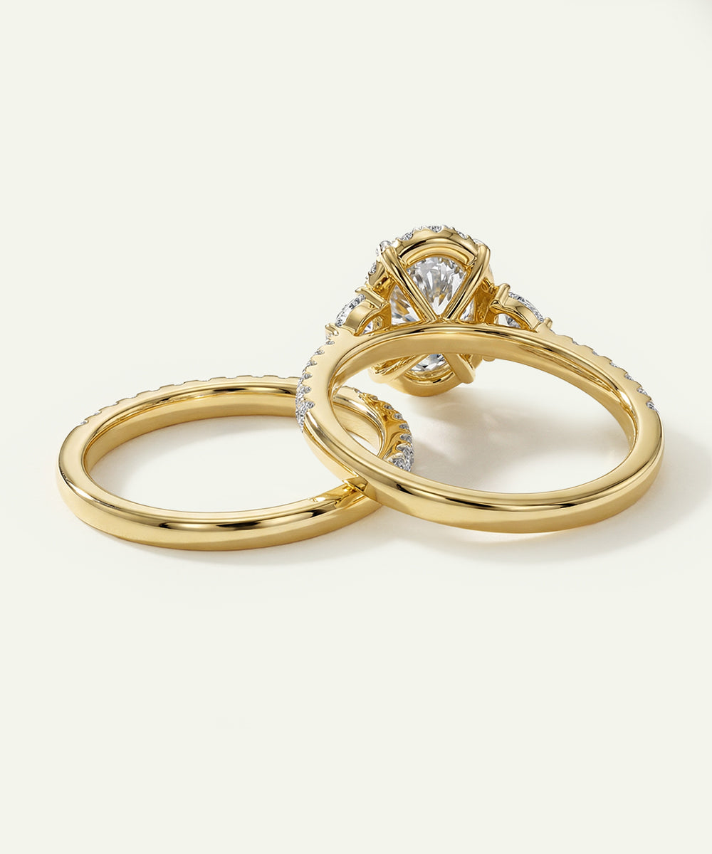Two gold rings with diamond accents on a light beige background