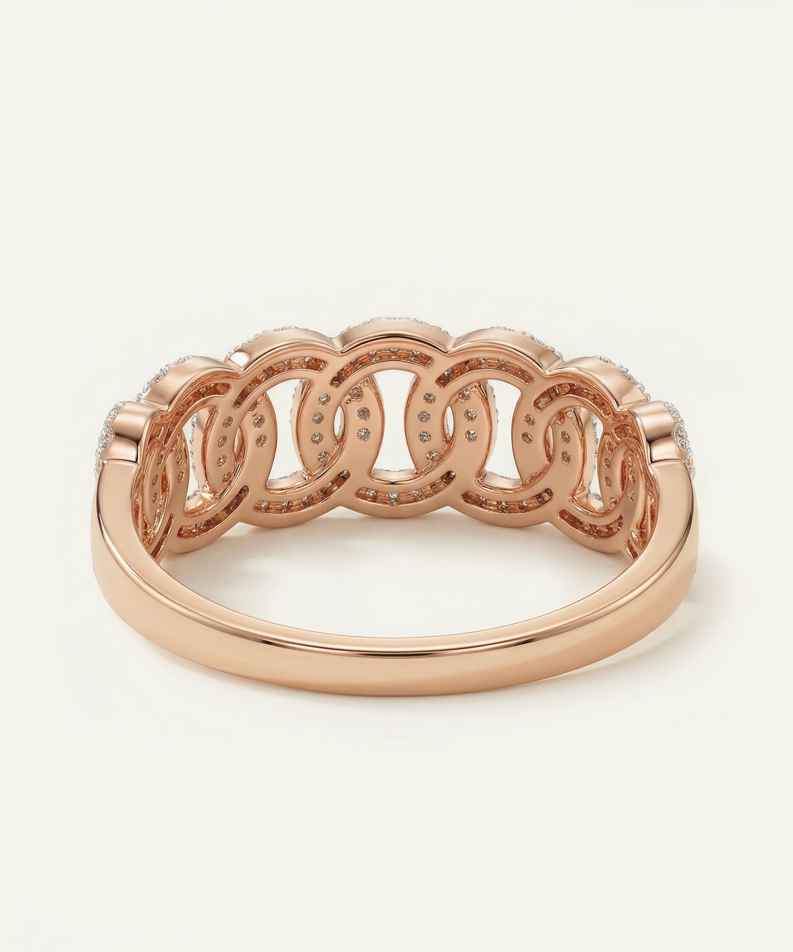 Rose gold ring with intricate design on a white background