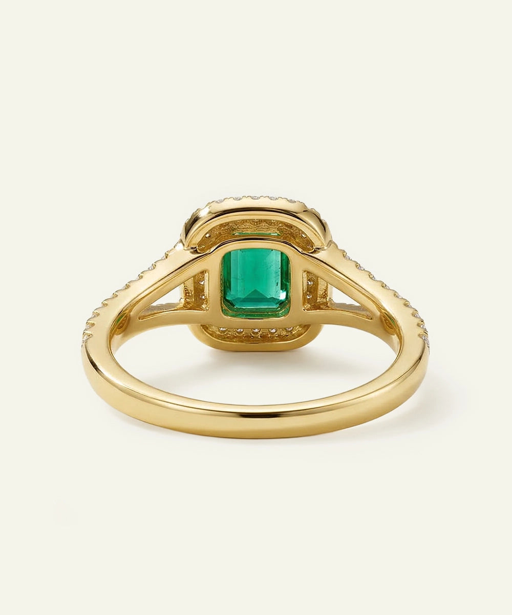 Gold ring with a green gemstone on a white background