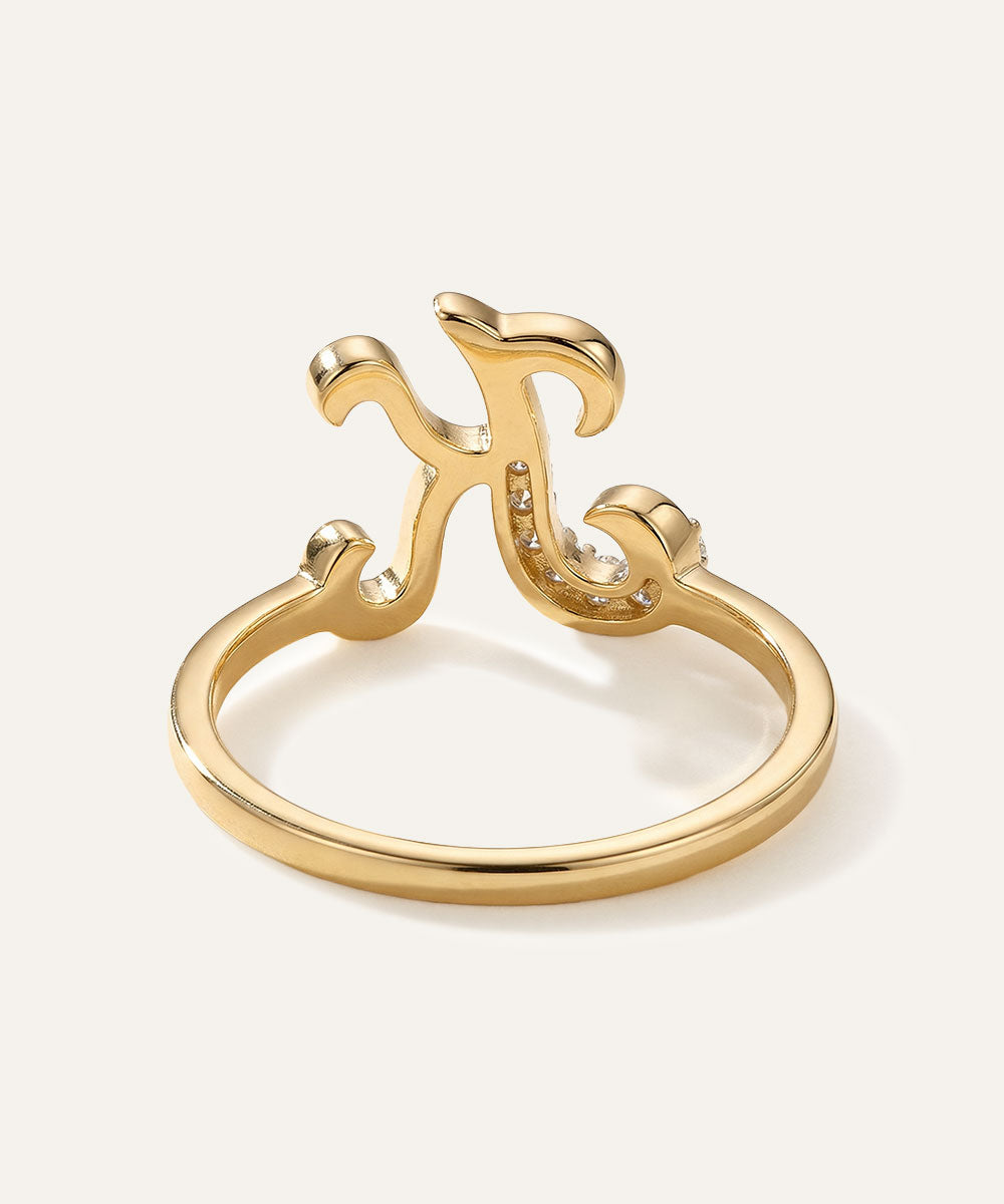 Gold ring with a decorative design on a light beige background