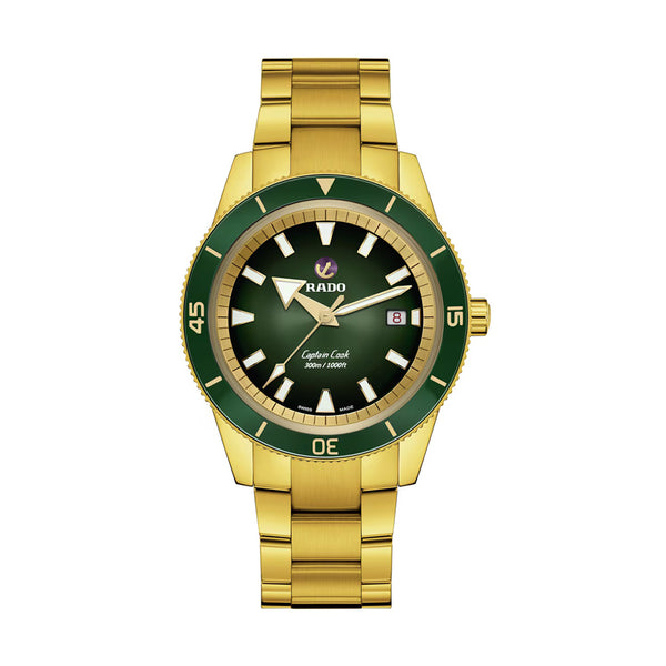 Gold watch with green bezel and black face on a white background