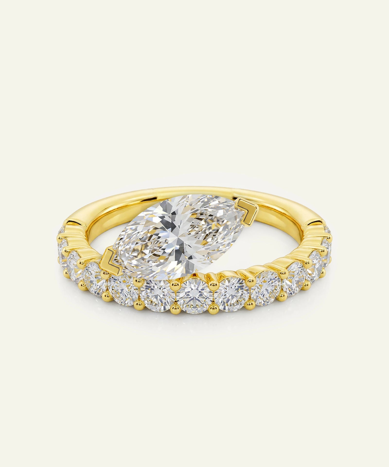 Gold ring with a large diamond and smaller diamonds on a light beige background
