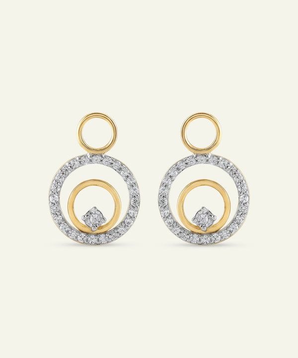 Pair of gold and silver hoop earrings on a light beige background