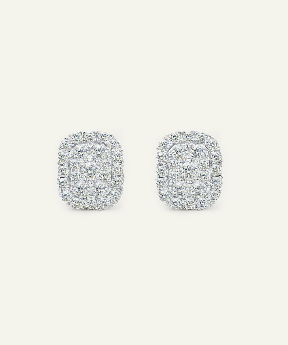 Pair of silver earrings with a textured design on a light gray background