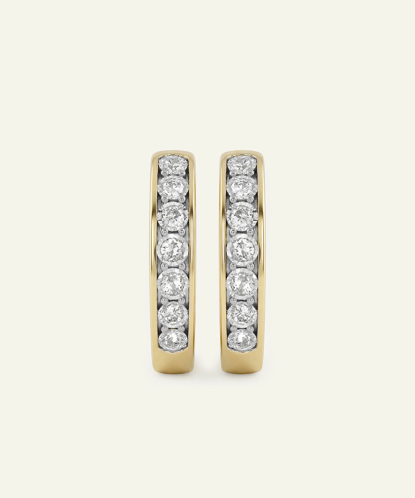 Pair of gold hoop earrings with embedded diamonds on a light gray background
